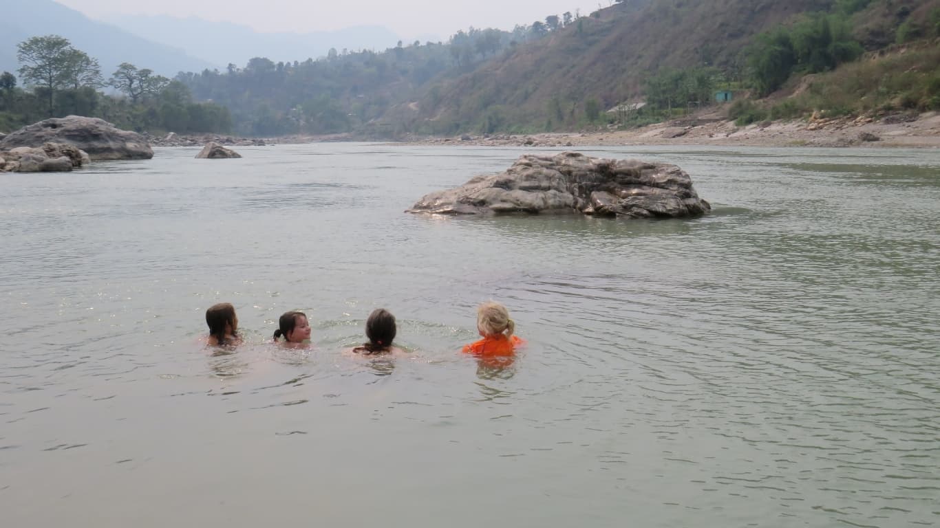 Girls playing in Trisuli river near Himalika Camp during a family adventure in Nepal