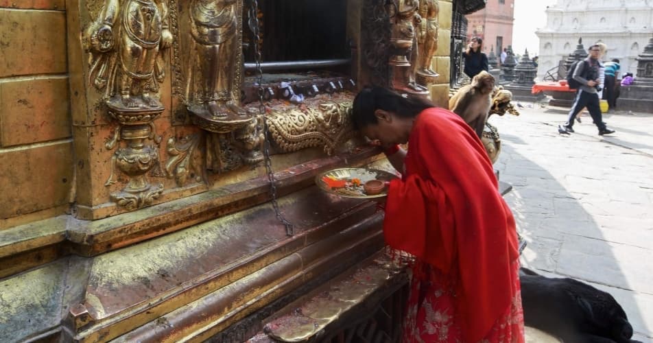 Spirituality is everywhere in Nepal, a woman bringing offering to a shrine