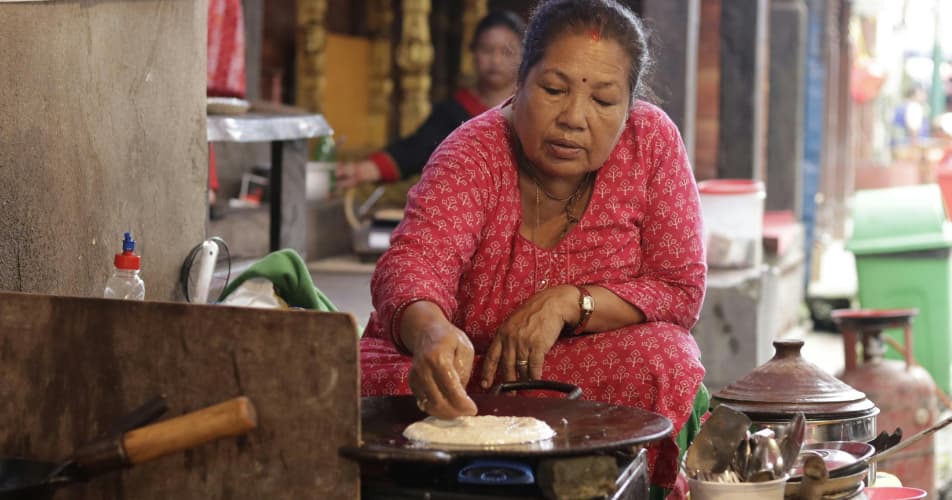 As part of Nepalese hospitality is a Nepalese women cooking for guests
